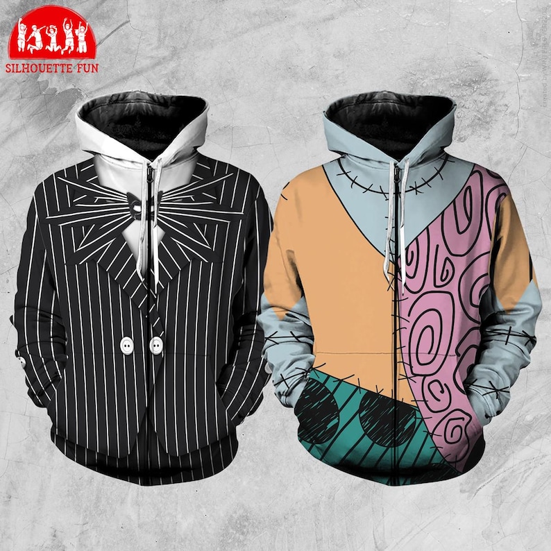 Puede incluir: Dos sudaderas con capucha y cremallera. Una es negra con rayas finas blancas, una pajarita y detalles de botones. La otra es un patchwork con secciones naranjas, azules y rosas, y detalles cosidos. Las sudaderas tienen capuchas negras y el logo Silhouette Fun.