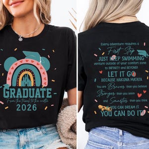 a woman wearing a black t-shirt with a colorful graphic and text on it. The text on the back of the t-shirt reads: "Graduate - From the Tissot to the Castle 2026".