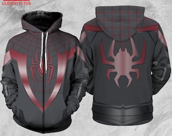 May include: A gray zip-up hoodie featuring a red spider web design and a large spider emblem on the front and back. The hoodie has a hood and a full-length zipper. The design is reminiscent of a superhero costume.