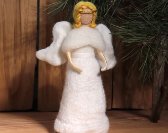 May include: A white felt angel ornament with blonde hair and a gold halo. The angel is wearing a white dress and has wings.