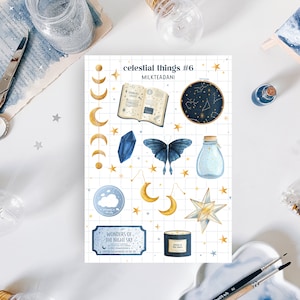 Può includere: Un foglio di adesivi a tema celeste con illustrazioni di lune, stelle, una farfalla, un cristallo, un barattolo e un libro. Gli adesivi hanno uno stile acquerello con accenti oro e blu. Il testo "celestial things #6" è visibile.