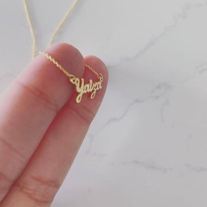 May include: A gold necklace with the name "Yalza" written in cursive script.