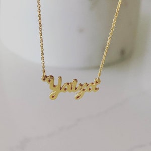 May include: A gold necklace with the name "Yaliza" spelled out in cursive.
