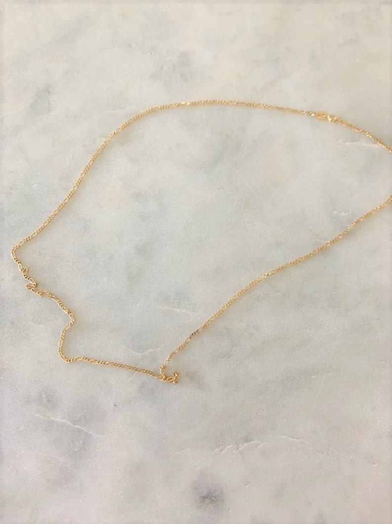 May include: A gold chain necklace with a delicate, twisted design.