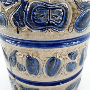 Peut inclure: Un pot en c&eacute;ramique blanche avec un motif floral bleu et blanc. Le pot a une large ouverture et un fond arrondi. Le motif floral pr&eacute;sente des feuilles et des fruits stylis&eacute;s.