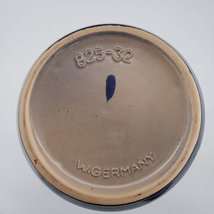 Peut inclure: Le dessous d'un vase en c&eacute;ramique bleu avec le num&eacute;ro "825-32" et le texte "W. Germany" imprim&eacute; au fond.