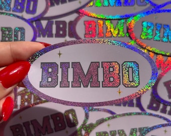 May include: Oval-shaped sticker with the word "BIMBO" in glittery, rainbow-colored letters. The sticker has a purple border and small star accents. Other stickers with the same design are visible in the background.