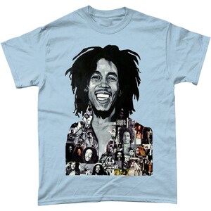 Op de afbeelding: Een lichtblauw T-shirt met een zwart-witte afbeelding van Bob Marley. De afbeelding is een collage van verschillende foto's van Bob Marley.