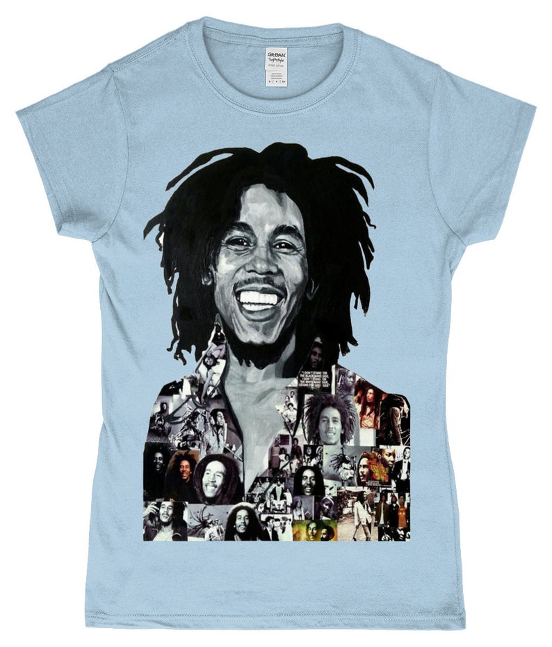May include: A light blue t-shirt featuring a black and white portrait of Bob Marley. The portrait is a collage of smaller images of Bob Marley.