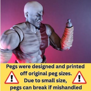 Könnte beinhalten: Detaillierte Actionfigur eines kahlen, muskulösen Charakters mit ernstem Gesichtsausdruck. Die Figur hat einen grauen Teint, rote Akzente und umwickelte Unterarme. Text auf einem gelben Banner warnt vor kleinen Stiften.