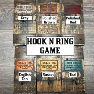 May include: A collection of Hook N Ring games, each mounted on a section of a wooden barrel. The games feature metal plates with the text "HOOK N RING" and color labels such as "Gray", "Polished Brown", and "Teal".