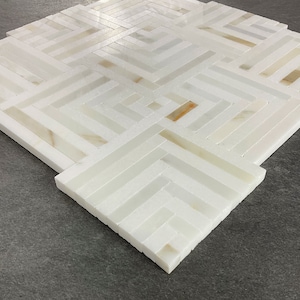 May include: White marble tile mosaic with a geometric pattern. The tiles are arranged in a herringbone pattern, creating a modern and stylish look.
