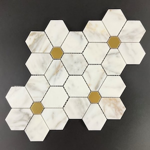 May include: White marble hexagon tiles with gold accents. The tiles are arranged in a honeycomb pattern.