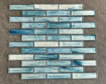May include: A sheet of blue and white glass mosaic tiles. The tiles are arranged in a brick pattern. The tiles have a subtle, iridescent sheen.