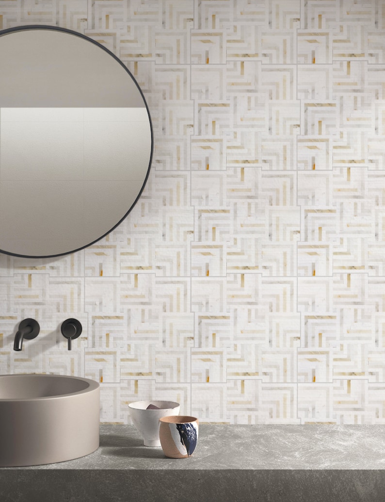May include: A bathroom vanity with a round mirror, two black faucets, a gray ceramic sink, and a white tiled wall with a geometric pattern. Three ceramic bowls are on the counter.