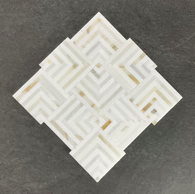 May include: White and gold geometric marble mosaic tile with a diamond shape.
