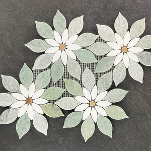 May include: A mosaic of green and white flower shapes with gold centers. The mosaic is made of small, individual pieces of stone.