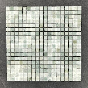 May include: Square mosaic tile sheet with a grid pattern. The tiles are small, square, and feature a mix of pale green and white tones. The grout lines are dark, creating a defined grid. The overall effect is a textured, natural look.
