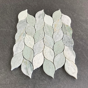 May include: Green and white marble leaf-shaped mosaic tiles arranged in a wave pattern. The tiles are approximately 1 inch wide and 2 inches long.