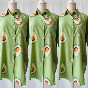 May include: Three green button-down shirts with a short sleeve and avocado print.