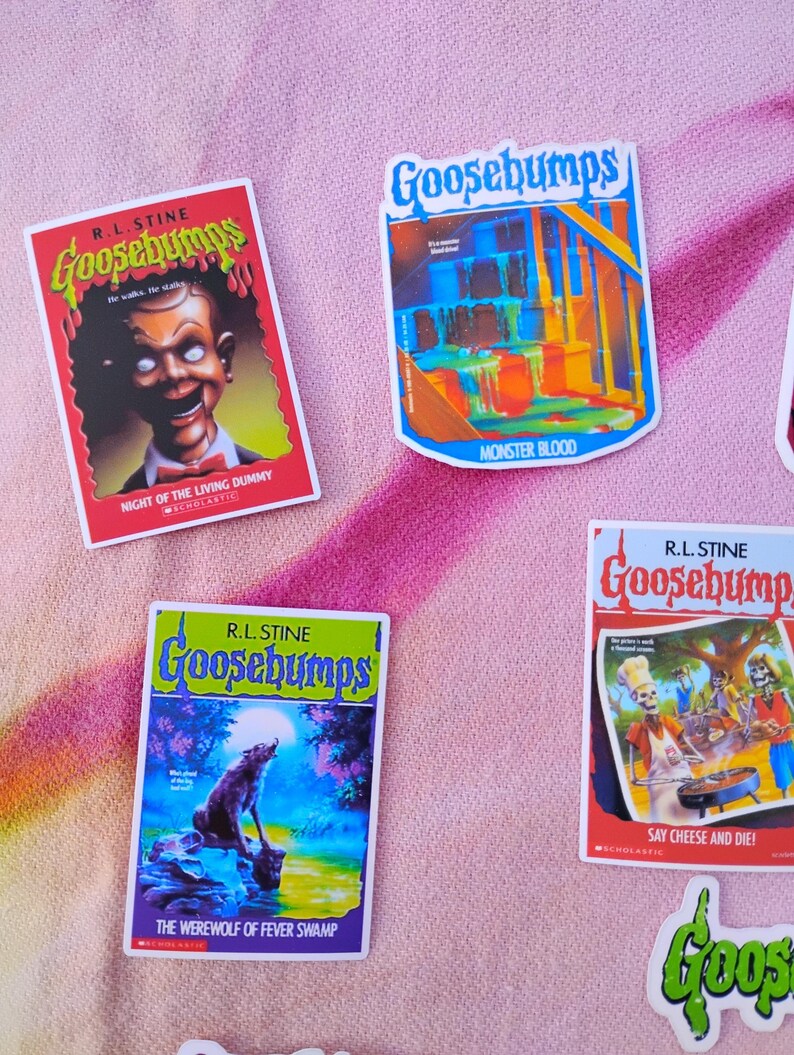 K&ouml;nnte beinhalten: Eine Sammlung farbenfroher Goosebumps-Aufkleber mit Buchcovern. Die Aufkleber zeigen Titel wie "Night of the Living Dummy", "Monster Blood", "The Werewolf of Fever Swamp" und "Say Cheese and Die!" auf einem rosa Hintergrund.