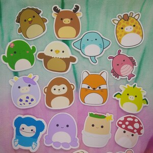 May include: A collection of colorful, die-cut stickers featuring various cartoon animals. The stickers include a dog, deer, giraffe, stingray, fish, cactus, eagle, cow, monkey, fox, dragon, octopus, and mushroom. Each sticker has a white border.