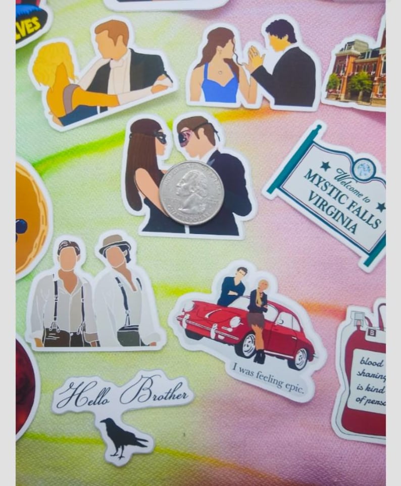 May include: A collection of stickers featuring various designs. Some stickers depict couples, a red car, and a sign that reads "Welcome to Mystic Falls Virginia." Other stickers include the text "Hello Brother" and "I was feeling epic."