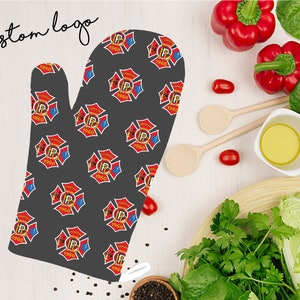 May include: A gray oven mitt with a repeating pattern of red and blue firefighter emblems. The emblems feature a crossed axe and hose, a letter "P", and the year "1960".