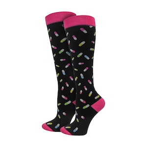 May include: A pair of black knee-high socks with a pattern of colorful pill-shaped designs. The socks have pink accents at the top, heel, and toe.