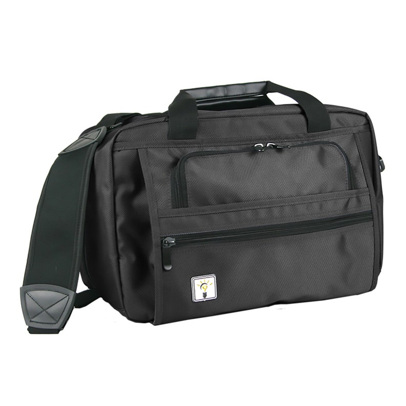 May include: Black messenger bag with a zippered pocket and a shoulder strap. The bag has a small logo with a lightbulb on it.