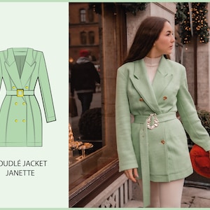 Può includere: Una giacca in bouclé verde chiaro con chiusura a doppio petto, bottoni dorati e cintura abbinata con una grande fibbia argentata. Il testo "BOUDLÉ JACKET JANETTE" è stampato sotto l'immagine.