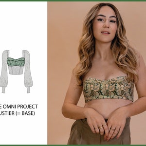 Może przedstawiać: Zielony top bustier z białym kwiatowym nadrukiem, dopasowanym gorsetem i długimi rękawami. Top jest pokazany na modelce na neutralnym tle. Tekst "THE OMNI PROJECT BUSTIER (= BASE)" jest wyświetlany pod obrazem.