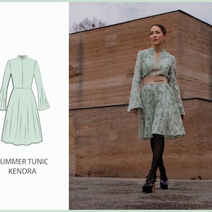 Può includere: Un abito tunica estivo verde menta con maniche svasate e vita aderente. L'abito presenta un colletto alto e una gonna fluida. L'immagine mostra anche una donna che indossa un abito con stampa floreale con cintura e scarpe con plateau. Il testo "SUMMER TUNIC KENDRA" è visualizzato.