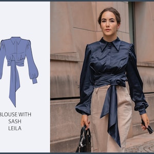 Peut inclure: Un chemisier bleu marine à manches longues et une ceinture qui se noue à la taille. Le chemisier a un col et une fermeture boutonnée. La ceinture est nouée en un nœud à l'avant de la taille.