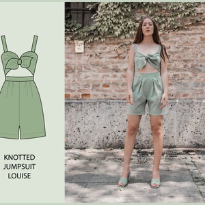Può includere: Una tuta verde annodata con un'apertura in vita. La tuta ha un fiocco in alto ed è di stile rilassato. La modella indossa la tuta con sandali.