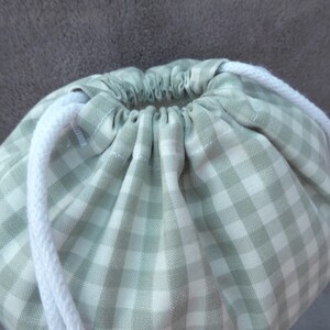 Handmade laundry bags and drawstring bags in a blue gingham cotton rich canvas fabric pull up with white cotton braided cords.
