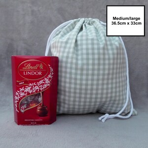 Handmade drawstring bags in a light sage green gingham cotton rich canvas fabric with white cotton braided cords.
Medium/large with drawcord - 36.5cm x 33cm