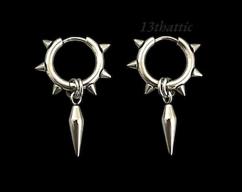 May include: A pair of silver hoop earrings with a spike design. Each earring has a small, pointed spike hanging from the hoop.