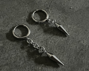 May include: A pair of silver hoop earrings with a dangling silver spike attached to a chain.