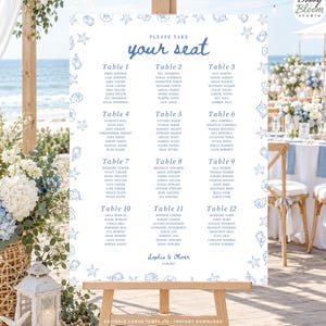 May include: A white wedding seating chart sign on a wooden easel featuring blue text that reads Please take your seat, lists tables 1 through 12 with guest names, and includes the names Sophia & Oliver with the date 18.09.2027 at the bottom.