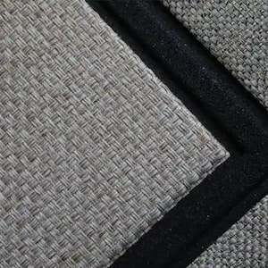 May include: Close-up of a woven grey mat with a black border. The mat has a textured surface and a geometric pattern. The black border adds a contrasting element to the design.