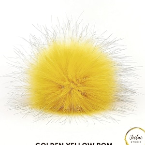 May include: A fluffy golden yellow pom pom, perfect for adding a touch of color and texture to any project.