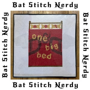 May include: A cross-stitch embroidery of a red bed with a yellow headboard and the words "one big bed" in yellow thread.