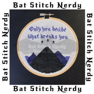 May include: Cross-stitch embroidery in a wooden hoop. The design features the text "Only you decide what breaks you" in purple, above a mountain scene in black and purple. The words "Bat Stitch Nerdy" are around the border.