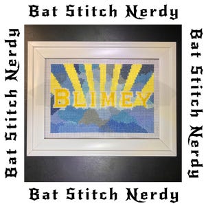 May include: Framed cross-stitch art with a white frame. The artwork features the word "BLIMEY" in yellow, set against a backdrop of blue and yellow rays. The words "Bat Stitch Nerdy" are printed around the frame.