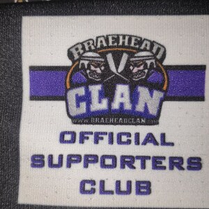 May include: White patch with a purple and gold logo that says "Braehead Clan" with two cartoon hockey players wearing helmets. Below the logo is the text "www.braeheadclan.com" and "Official Supporters Club".