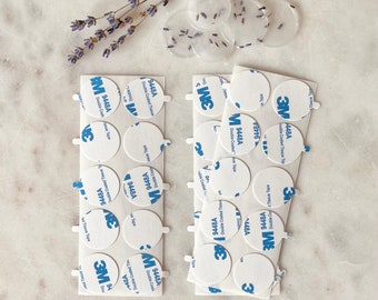 May include: A close-up of two sheets of white, round, adhesive stickers. Each sticker has a blue 3M logo and the text "9448A Double Coated Tissue Tape".