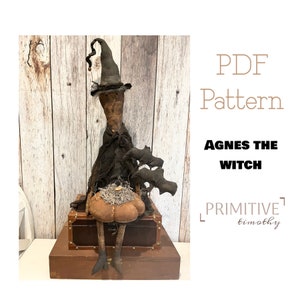 May include: A handcrafted Halloween witch doll named Agnes, wearing a black hat and dress, with bat decorations. The doll is sitting on a wooden box, with a pumpkin. The text "PDF Pattern" and "Agnes the Witch" are visible.