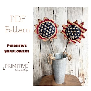 May include: Two red, white, and blue fabric sunflowers with a rustic wood stem in a galvanized metal vase.  PDF Pattern Primitive Sunflowers by Timothy.