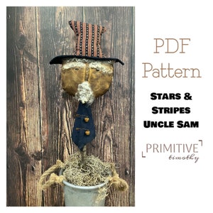 May include: A PDF pattern for a primitive doll, Uncle Sam, with a red, white, and blue striped hat and a blue tie. The doll is standing in a pot with moss. The text on the image reads "PDF Pattern Stars & Stripes Uncle Sam Primitive Timothy".